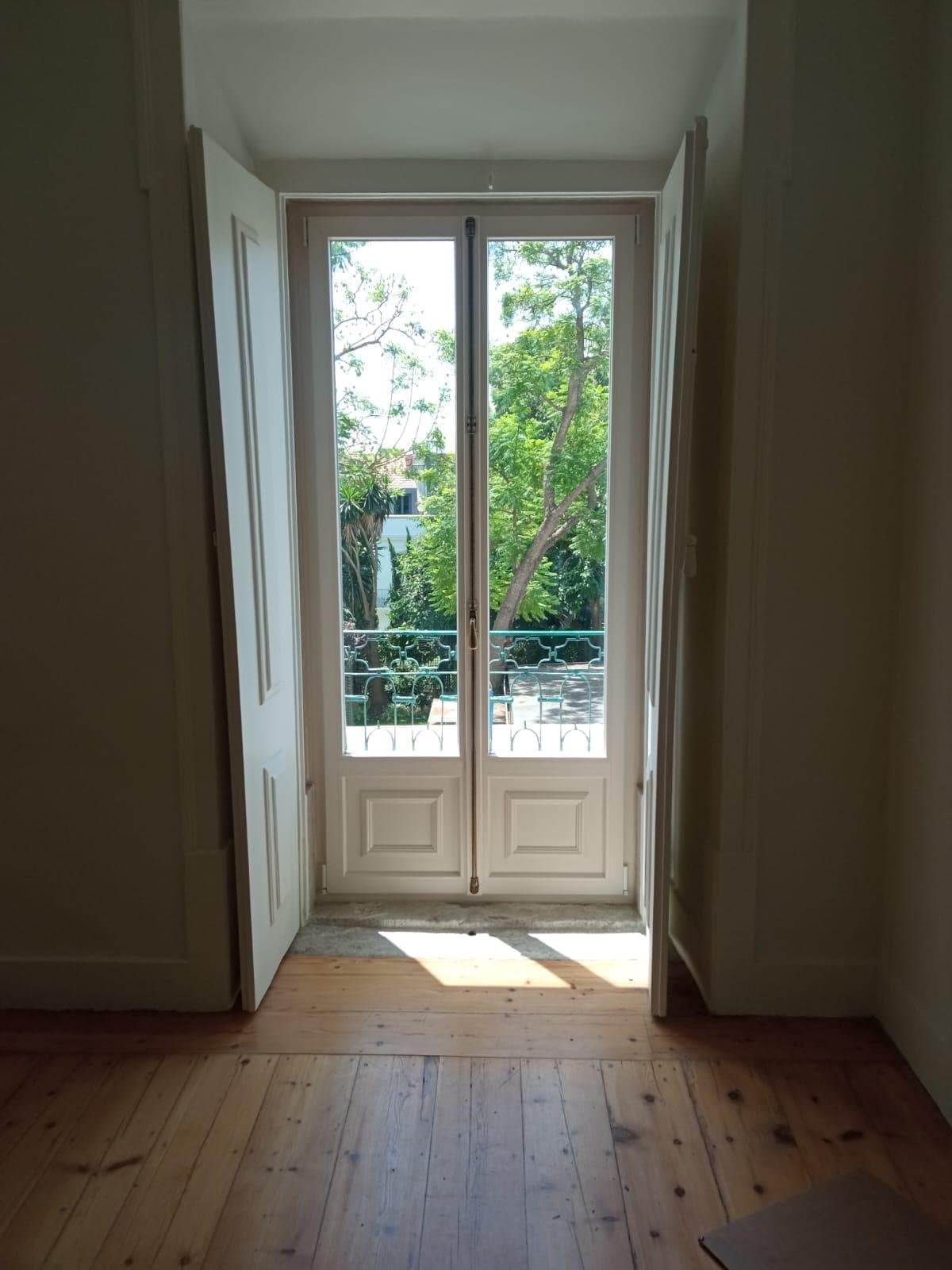Porta de varanda em PVC instalada pela Deleme, com vista para árvores