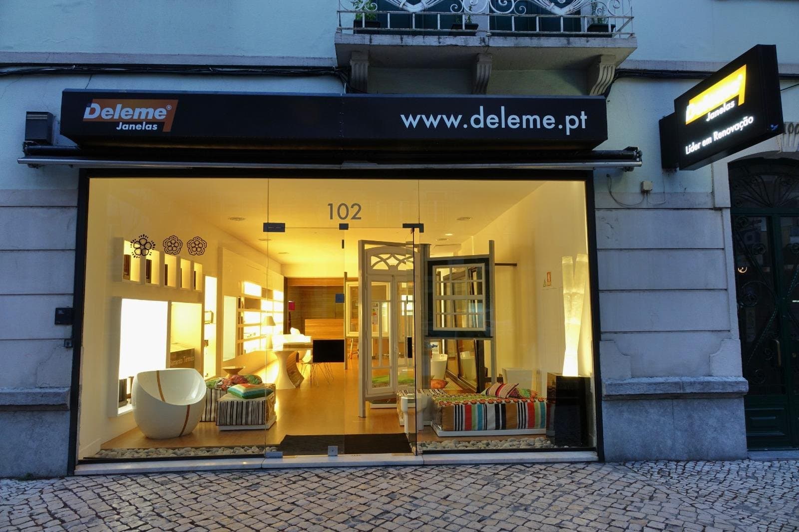 Showroom Deleme em Lisboa iluminado à noite, com letreiro Deleme